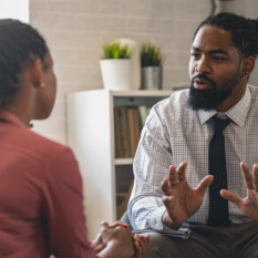 A psychotherapist session with a patient. African-American women and men have a meeting. 