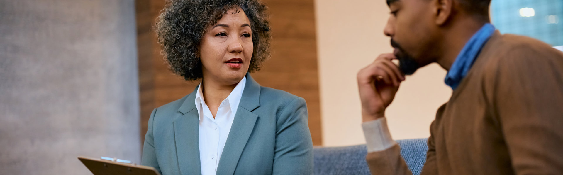 Insurance agent and her client talking terms of a contract during the meeting.